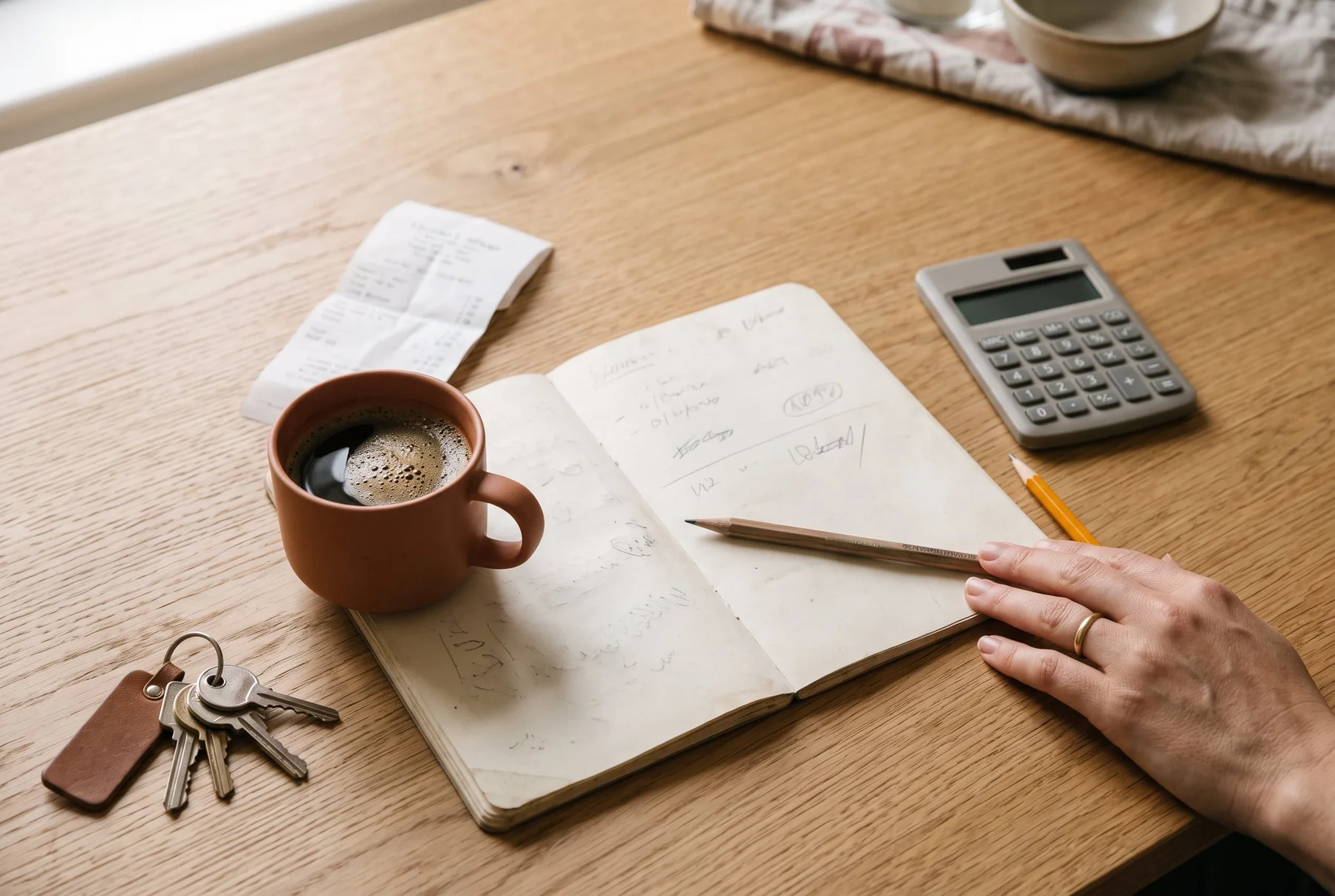 Notebook, household keys and calculator arranged for a budget review